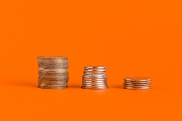 Stack of cash coins showing increase graph on color surface