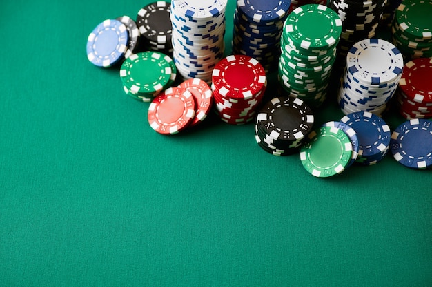 Stack of casino gambling chips on green table