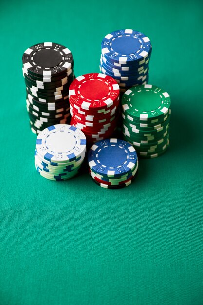 Stack of casino gambling chips on green table