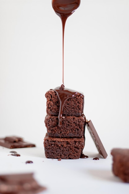 A stack of chocolate brownies on top with chocolate sauce