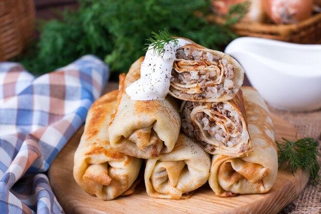 Stack of classic crepes on a plate surrounded by ingredients