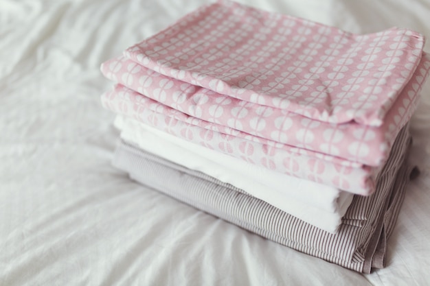 A stack of clean and ironed linen is on the bed