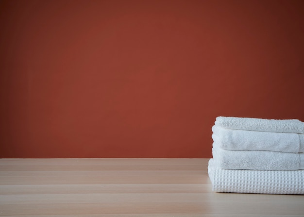 Stack of clean towels and bathrobe on table