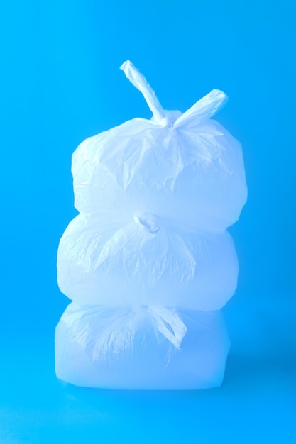 Stack of clear disposable plastic bags on blue background.