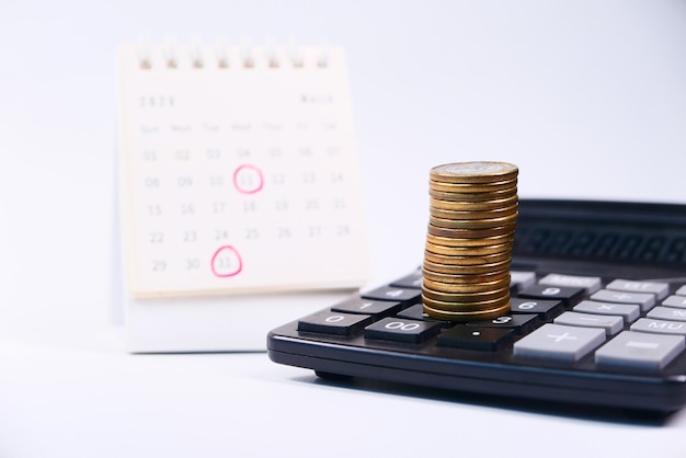 Stack of coins and calendar isolated