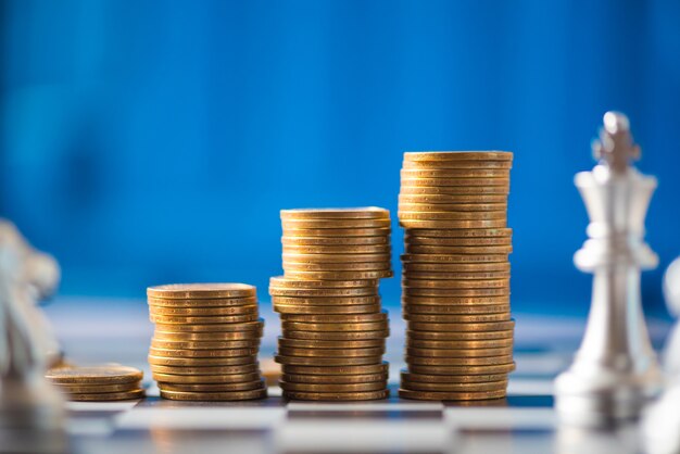 stack of coins on a chessboard, business strategy concept