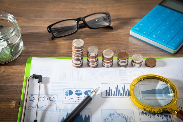 Stack of coins on financial graphs