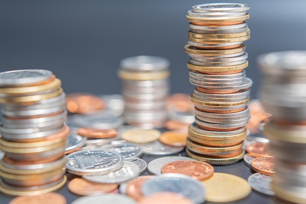 Stack of coins and heap coins on black table