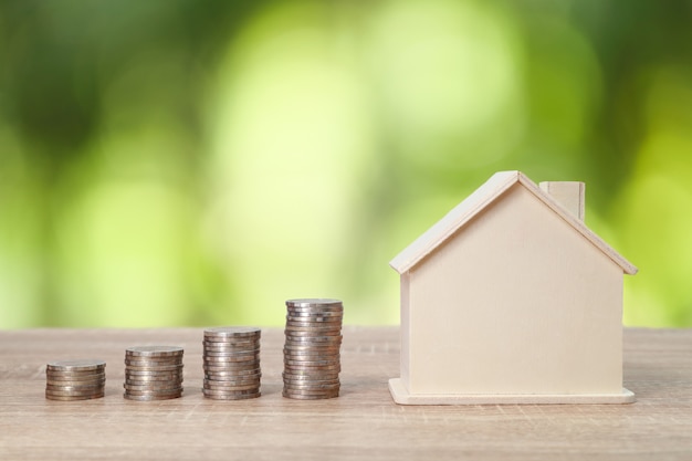 Stack coins with house on wood table 