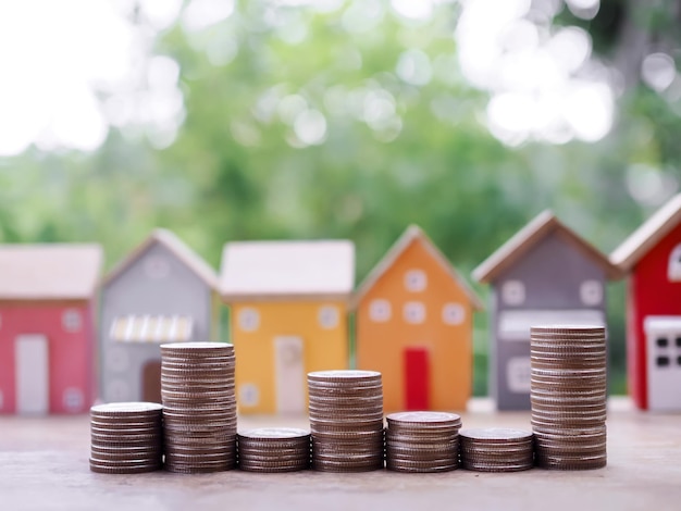 Photo stack of coins with miniature house background the concept of saving money for house property investment house mortgage real estste