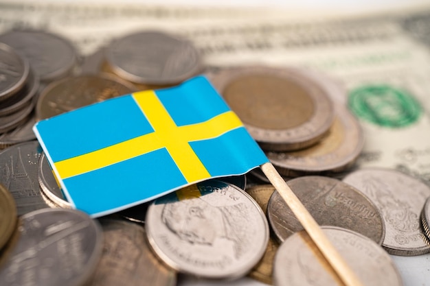 Stack of coins with Sweden flag on USA America dollar banknotes