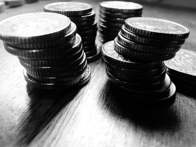 Stack on coins on wooden table