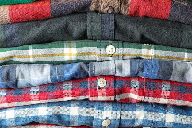 Photo stack of colorful shirts as background, space for text