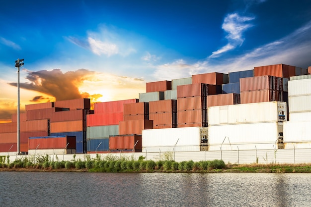 Stack of container at the riverside industrial estate on sunset background