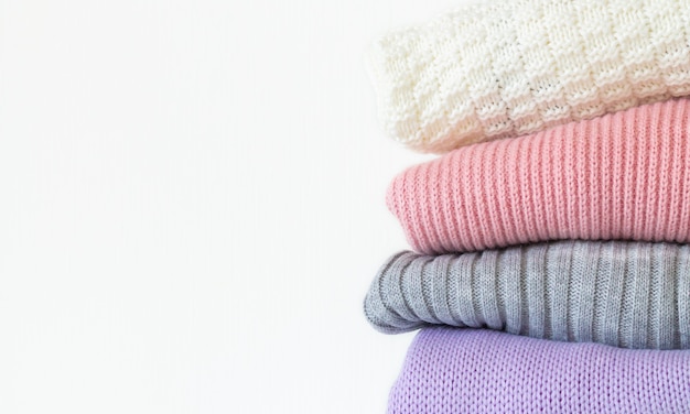 Stack of cozy knitted winter sweaters
