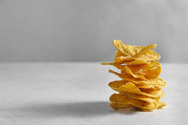 A stack of crispy potato chips on a white stone table