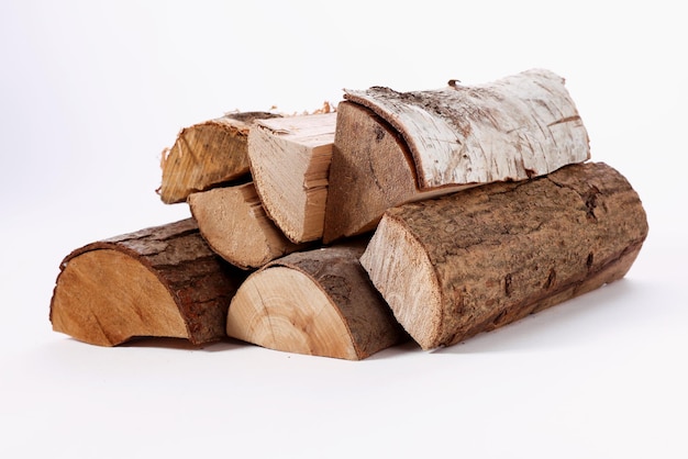 Stack of cut assorted tree trunks on white surface