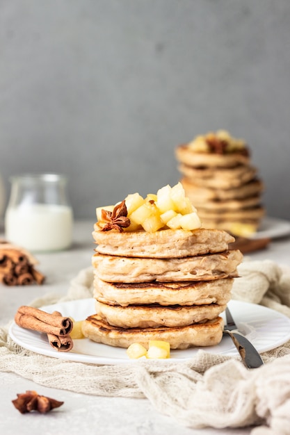 Stack of delicious apple pancakes with fried caramelized apples and spices. 