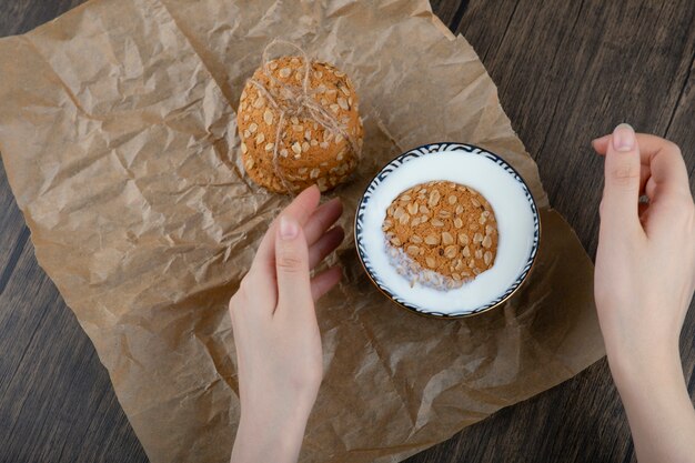 Stack of delicious cookies with cereals and a bowl of fresh milk. 