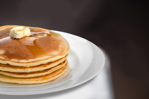 Stack of delicious pancakes on white plate