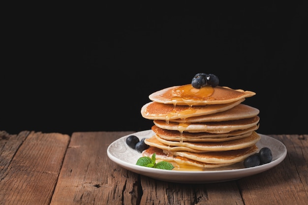 A stack of delicious pancakes with honey.