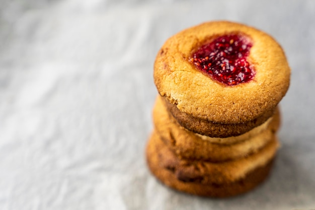 Stack of delicious warm homemade cookies on white baking\
paper
