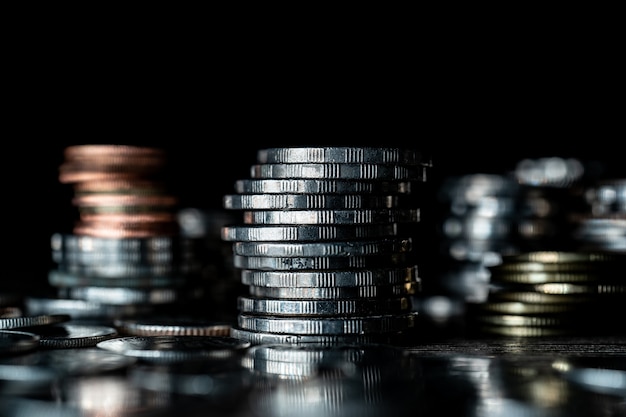 Stack of different coins on dark