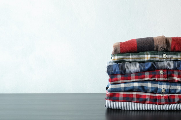 Stack of different shirts on black table