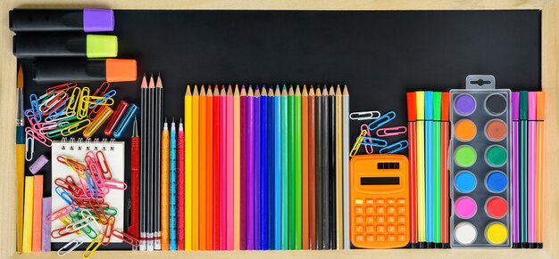 Stack of diffrent education supply on blackboard