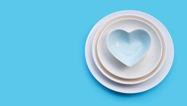 Stack of dishes on blue background. Copy space