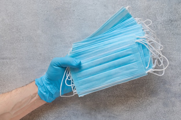 Stack of disposable medical protective masks in the hand