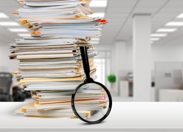 Stack of documents and magnifying glass