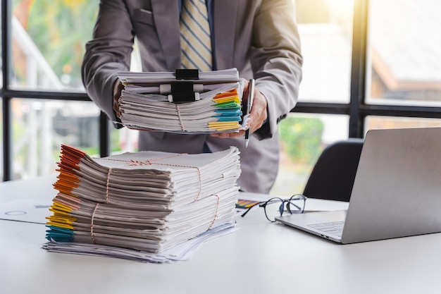 Stack of documents pile of papers on office desk employee\'s\
table closeup asian people