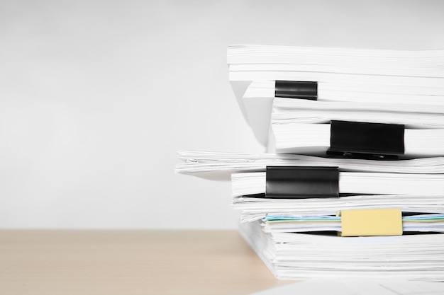 Stack of documents on table against light background