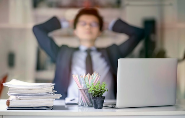 Stack of documents at workplace and blur image of male employee 