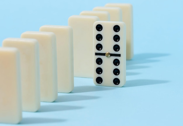 Foto una pila di domino su sfondo blu un gioco intellettuale