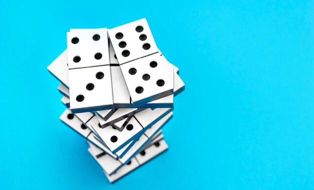 Stack of dominoes on a blue Top view Copy space for text