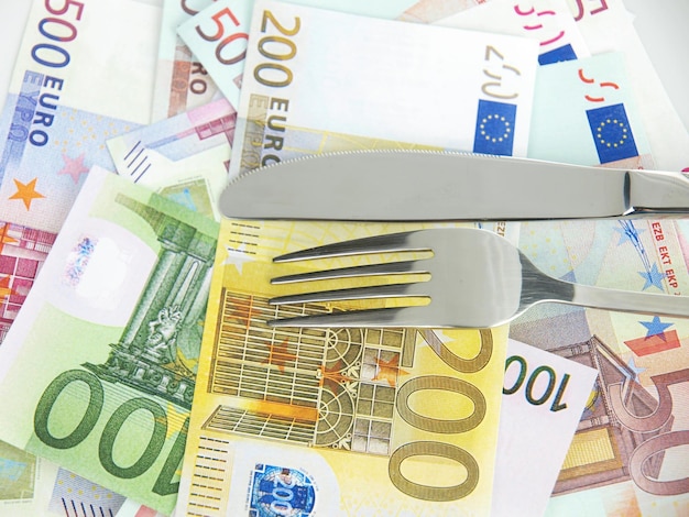 A stack of euro banknotes with a fork on it