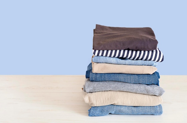 stack of folded clothes closeup on table against blue background