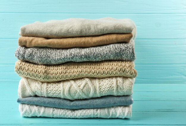 Stack of folded clothes on wooden background