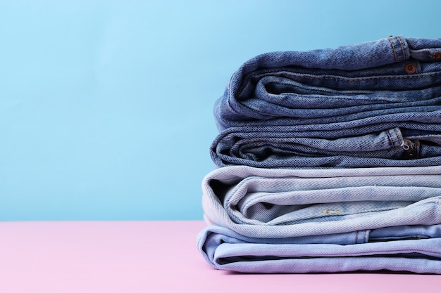 Premium Photo | Stack of folded jeans on the table