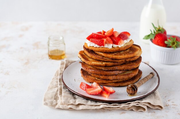 Stack of french toast with cottage cheese, honey and strawberries for breakfast