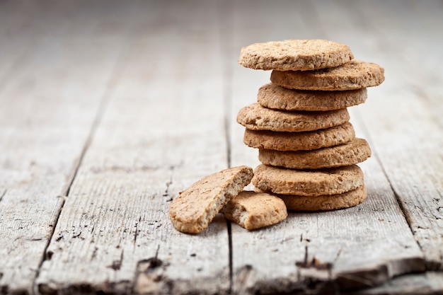 Stack of fresh baked oat cookies on rustic wooden table