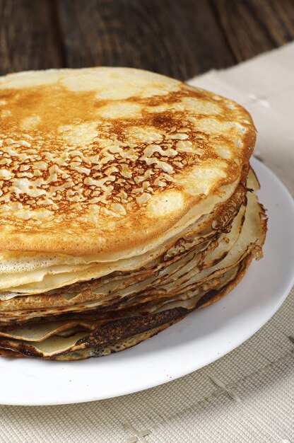 Stack of fried pancakes on kitchen table closeup