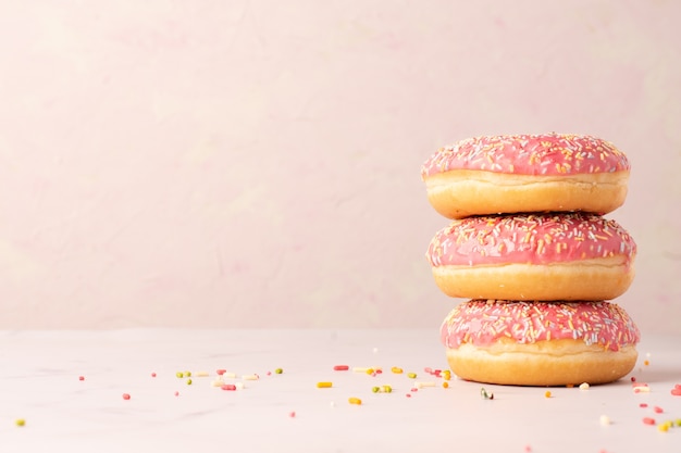 Photo stack of glazed doughnuts with copy space and sprinkles