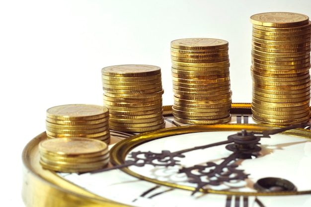 stack of gold coins on the vintage clock