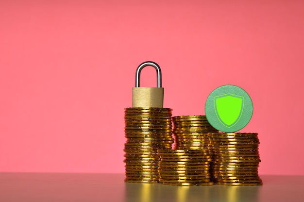 Photo stack of golden coins padlock and insurance symbol money protection concept
