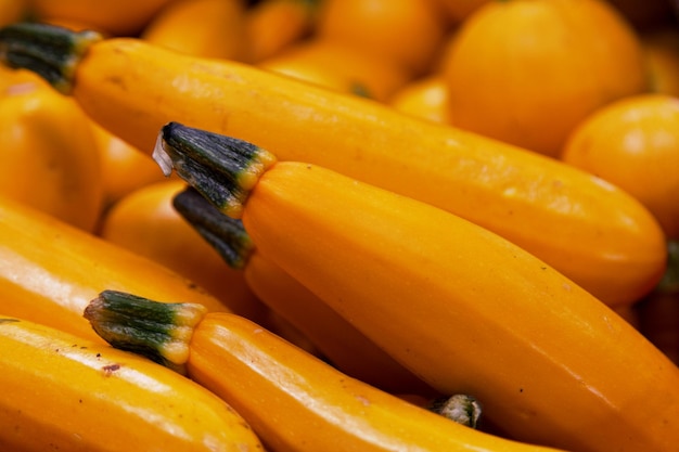 Stack of Golden zucchini on a market stall