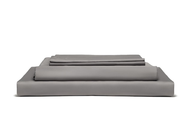 白い背景で隔離の灰色の折り畳まれた寝具シーツのスタック