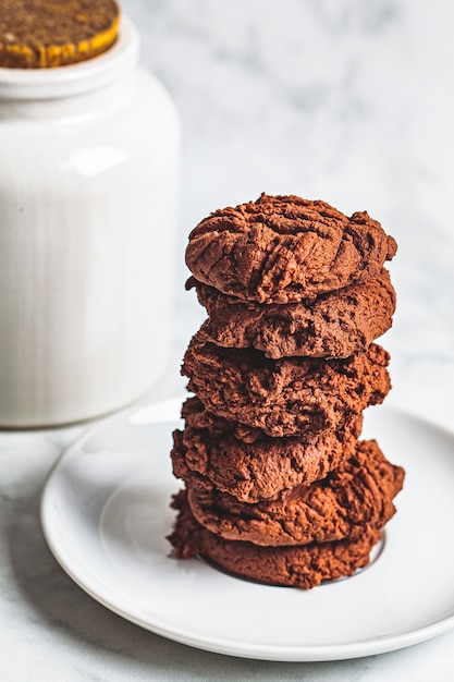 A stack of homemade chocolate chip cookies on a white saucer